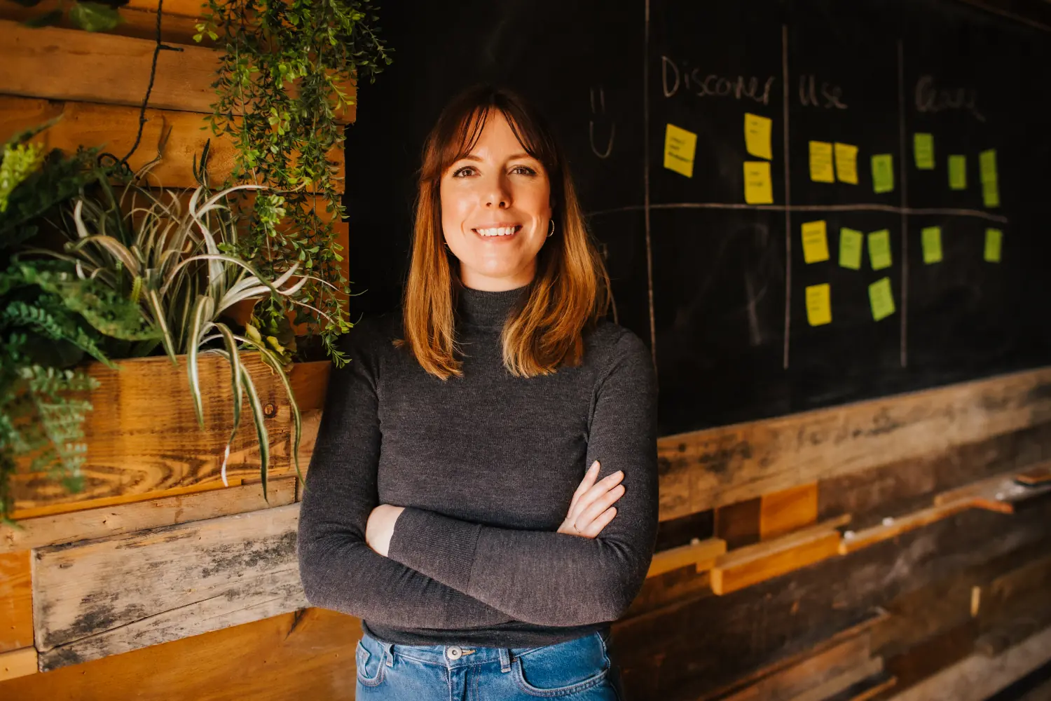 Amy standing, smiling, by a board covered in hand written notes.
